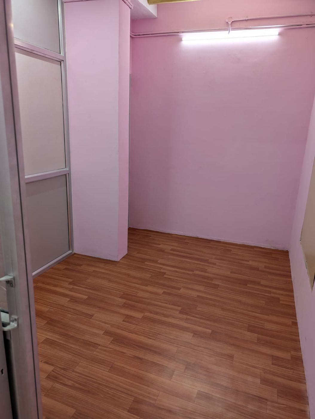 Room seen from the doorway, with a tube light above