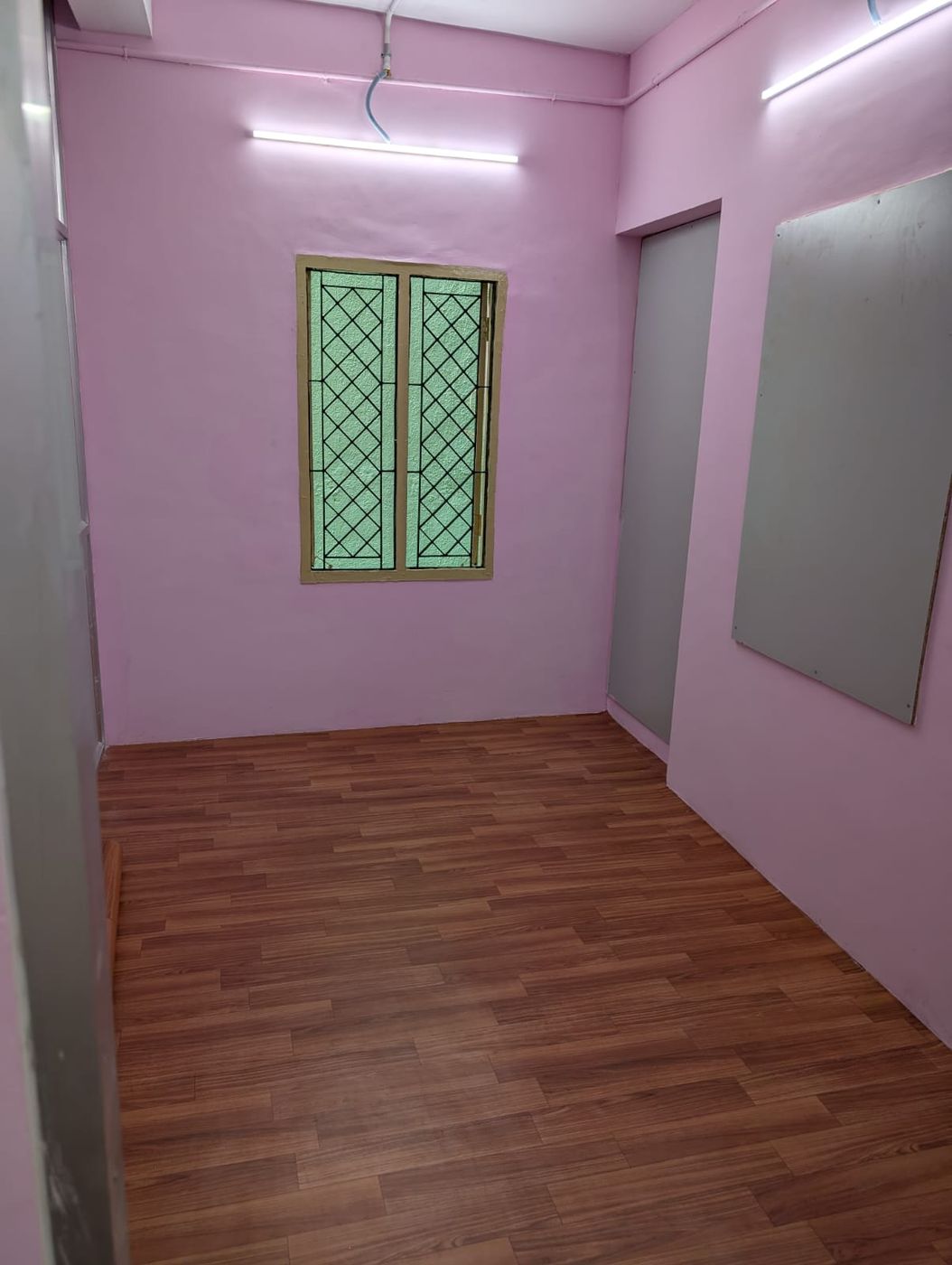 Room with a window, a door and a wall-mounted board